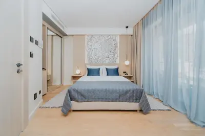 a bedroom with a bed and a large window at Katamare Hotel in Budva