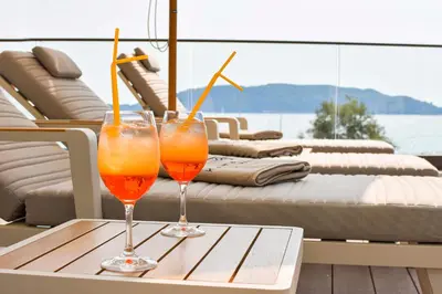 two glasses of orange juice sitting on a table on a boat at Katamare Hotel in Budva