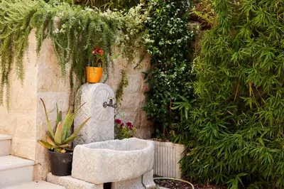 a stone fountain in a garden with plants at Przice Gardens Apartment with Pool in Kotor