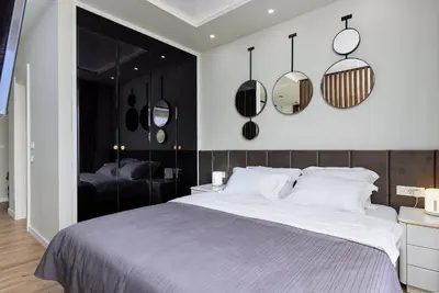 a bedroom with a large bed and mirrors on the wall at Przice Gardens Apartment with Pool in Kotor