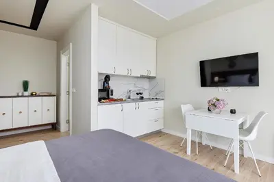 a white room with a bed and a desk and a kitchen at Przice Gardens Apartment with Pool in Kotor
