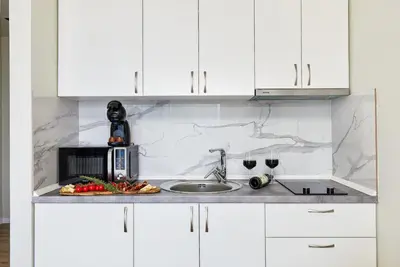 a kitchen counter with a microwave and a plate of food at Przice Gardens Apartment with Pool in Kotor