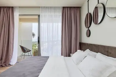 a bedroom with a bed and a large window at Przice Gardens Apartment with Pool in Kotor