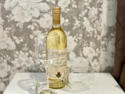 a bottle of wine sitting next to a wine glass at Olive Square Apartment Budva in Budva
