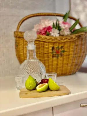 a cutting board with pears and a basket of flowers at Olive Square Apartment Budva in Budva