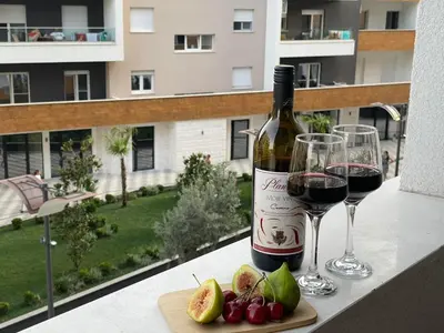 a bottle of wine and two glasses on a table at Olive Square Apartment Budva in Budva