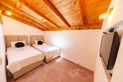 a bedroom with two beds and a flat screen tv at Villa Helena in Kotor