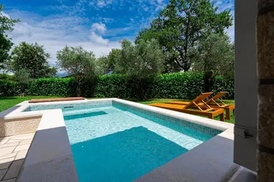 a swimming pool in a yard with two chairs at Villa Helena in Kotor