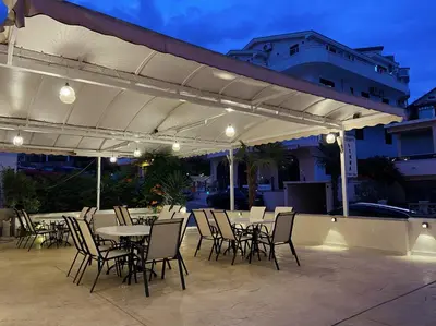 a patio with tables and chairs under a white canopy at Donna in Ulcinj