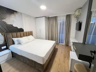 a bedroom with a bed and a desk and a television at Donna in Ulcinj