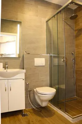 a bathroom with a shower and a toilet and a sink at Eagles Apartments & Suites in Ulcinj