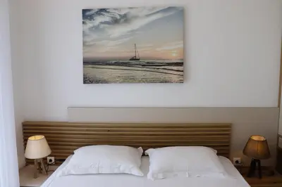 a bedroom with a bed and a sailboat in the water at Eagles Apartments & Suites in Ulcinj