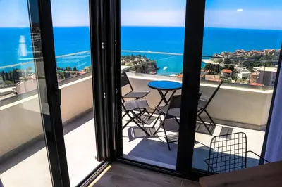 a balcony with chairs and a table on a balcony at Eagles Apartments & Suites in Ulcinj