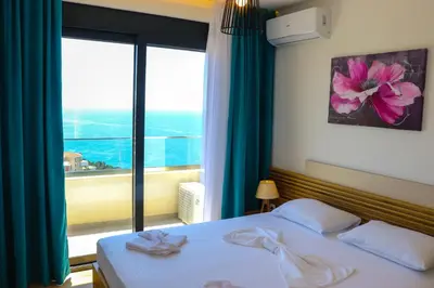 a bedroom with a bed and a large window at Eagles Apartments & Suites in Ulcinj