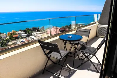a balcony with a table and two chairs and the ocean at Eagles Apartments & Suites in Ulcinj