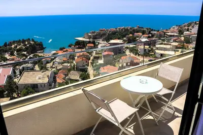 a balcony with a table and chairs and the ocean at Eagles Apartments & Suites in Ulcinj
