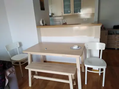 a table and two chairs in a room with a kitchen at Stan Budva Apartman in Budva