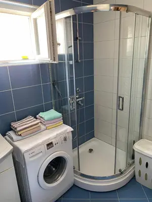 a washing machine in a bathroom with a shower at Stan Budva Apartman in Budva