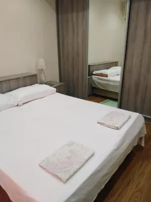 a bedroom with a white bed and a mirror at Stan Budva Apartman in Budva
