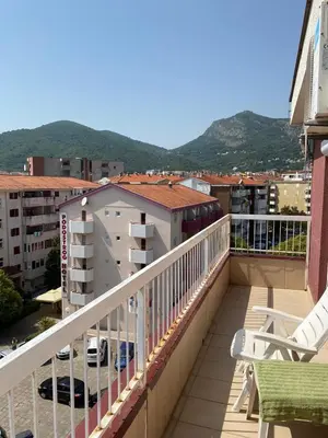 a balcony with chairs and a view of a city at Stan Budva Apartman in Budva