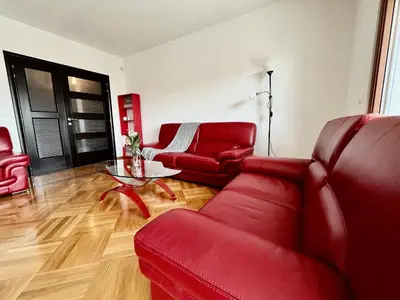a living room with red furniture and a glass table at Apartment MERCURY in Budva
