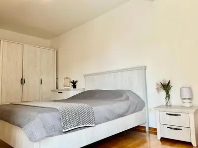 a white bedroom with a bed and cabinets at Apartment MERCURY in Budva