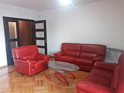 a living room with two red chairs and a glass table at Apartment MERCURY in Budva