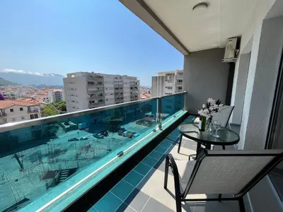 a balcony with a swimming pool and a table and chairs at Apartment MERCURY in Budva