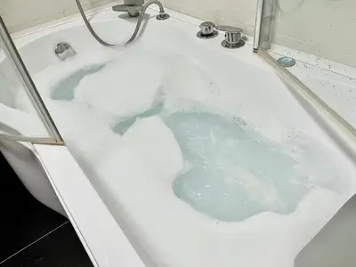 a bath tub filled with lots of blue water at Apartment MERCURY in Budva