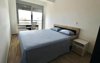 a bedroom with a bed and a desk and a window at 1bd Sea View Apts Veliki Pjesak 