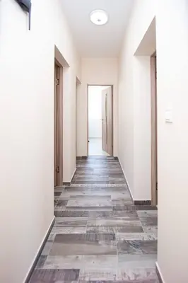 an empty corridor of an empty room with white walls and wooden floors at Aquamarine House in Tivat