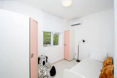 a bedroom with a bed and a window at Aquamarine House in Tivat