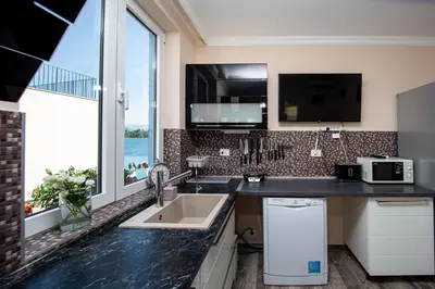 a kitchen with a sink and a large window at Aquamarine House in Tivat