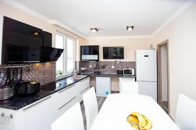 a kitchen with white appliances and black counter tops at Aquamarine House in Tivat