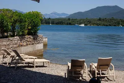 a group of chairs and a table next to a lake at Aquamarine House in Tivat