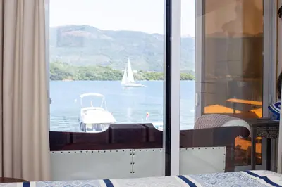 a bedroom with a view of a boat in the water at Aquamarine House in Tivat