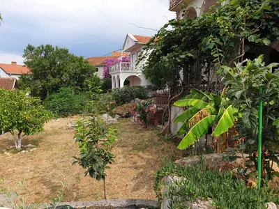 a house with a yard with trees and plants at Apartman Veliki Pijesak in Dobra Voda
