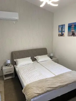 a bedroom with a bed and two night stands at Viola Apartmanházak Family Apartman in Donji Susanj