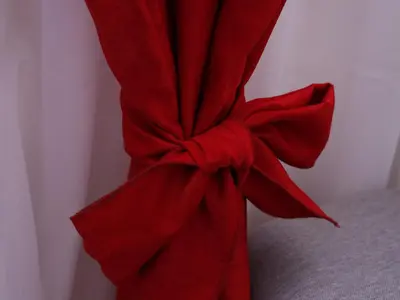 a red curtain tied up with a red bow at Apartment Mona in Podgorica