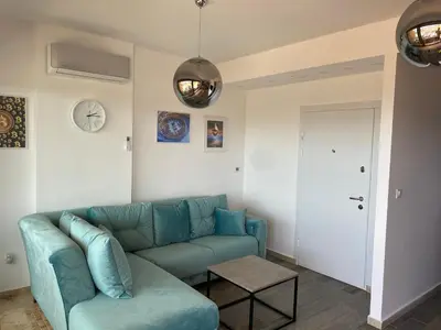 a living room with a blue couch and a table at Bitcoin and Ethereum Deluxe Apartments in Bar