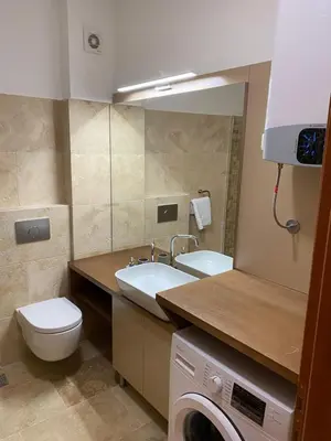 a bathroom with a toilet and a sink and a washing machine at Bitcoin and Ethereum Deluxe Apartments in Bar