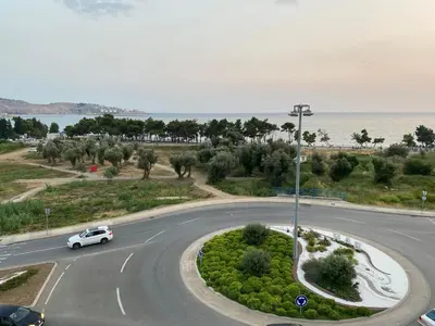 a white car driving down a road near the ocean at Bitcoin and Ethereum Deluxe Apartments in Bar