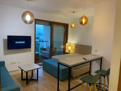 a living room with a table and a dining room at Bitcoin and Ethereum Deluxe Apartments in Bar