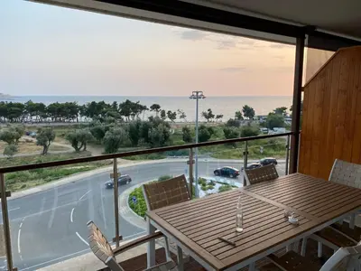 a balcony with a table and chairs and a view of the ocean at Bitcoin and Ethereum Deluxe Apartments in Bar