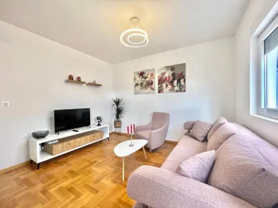 a living room with a couch and a tv at Azure Apartments in Budva
