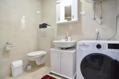 a bathroom with a washing machine and a sink at Azure Apartments in Budva