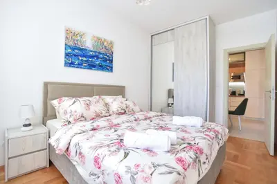 a bedroom with a large bed with pink flowers at Azure Apartments in Budva