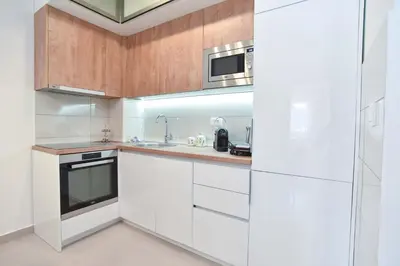 a white kitchen with a sink and a microwave at Azure Apartments in Budva