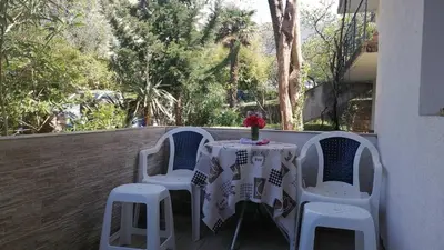 a table and four chairs on a balcony with a table and flowers at Candy apartment central location Bečići in Becici