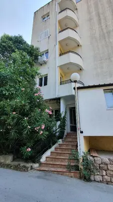 a building with stairs and a tree next to it at Candy apartment central location Bečići in Becici